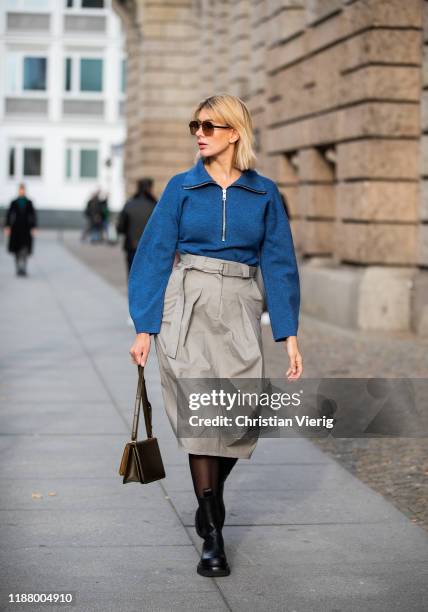 Victoria Nasir is seen wearing grey high waist cargo skirt Tibi, blue sweater with zipper Tibi, black boots Bottega Veneta, sheer tights, BV classic...