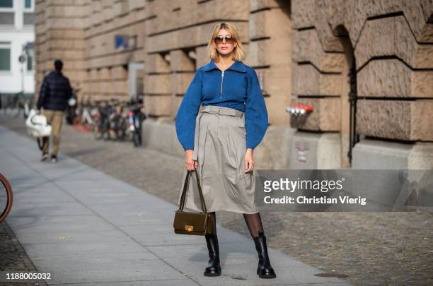 Victoria Nasir is seen wearing grey high waist cargo skirt Tibi, blue sweater with zipper Tibi, black boots Bottega Veneta, sheer tights, BV classic...