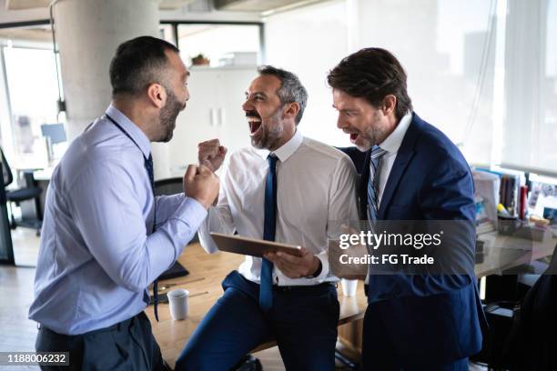 colleghi che guardano un po ' di sport al tablet digitale e festeggiano al lavoro - sport office foto e immagini stock