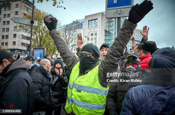 Gilet Jaune, or yellow vest protestor holds a brick in the air and chants against President Macron as tens of thousands of protesters are expected to...