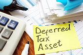 Deferred tax asset handwritten sign and calculator.
