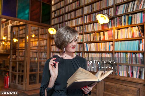 beautiful woman reading book - 40 year old woman blonde blue eyes stock pictures, royalty-free photos & images