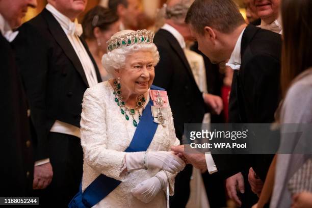 Queen Elizabeth II talks to guests at an evening reception for members of the Diplomatic Corps at Buckingham Palace on December 11, 2019 in London,...