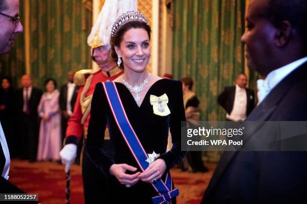 Catherine, Duchess of Cambridge talks to guests at an evening reception for members of the Diplomatic Corps at Buckingham Palace on December 11, 2019...