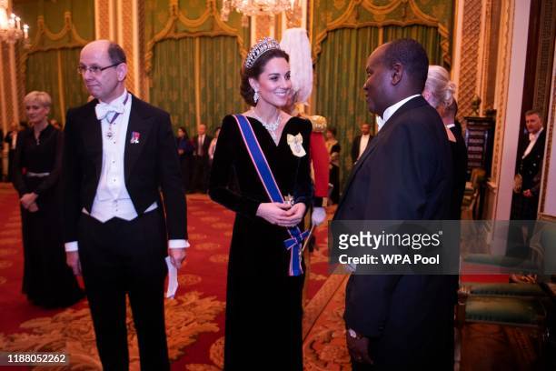 Catherine, Duchess of Cambridge talks to guests at an evening reception for members of the Diplomatic Corps at Buckingham Palace on December 11, 2019...