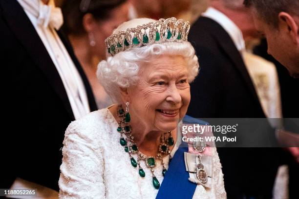 Queen Elizabeth II talks to guests at an evening reception for members of the Diplomatic Corps at Buckingham Palace on December 11, 2019 in London,...