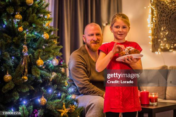 christmas oliebollen for father and daughter in xmas home - oliebol stock pictures, royalty-free photos & images