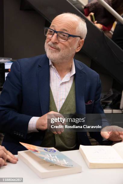 American writer Andre Aciman signs copies after the presentation of his new book "Cercami" on November 16, 2019 in Sesto San Giovanni, Italy.