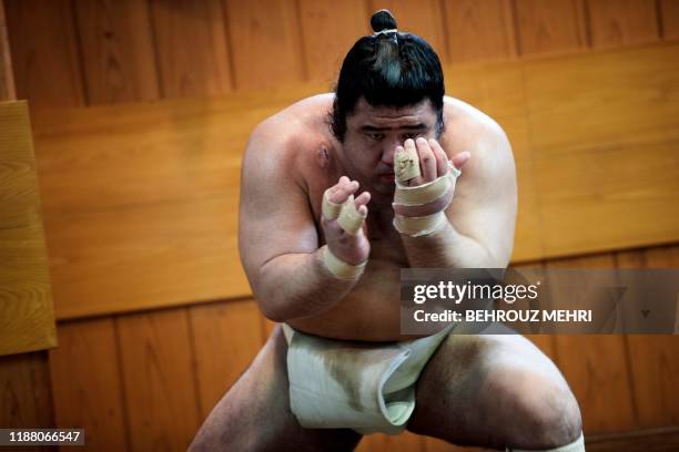 In this picture taken on August 28 a sumo wrestler exercises during a training session at a stable in Tokyo. - The quintessentially Japanese sport of...