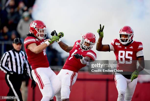 Matt Alaimo and Daevon Robinson celebrate with Isaih Pacheco of the Rutgers Scarlet Knights after his touchdown in the first quarter of their game...