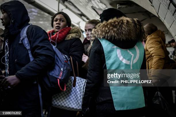 Commuters wait for a train on a platform of the subway line 1 during a strike of public transports operator SNCF and RATP employees over French...