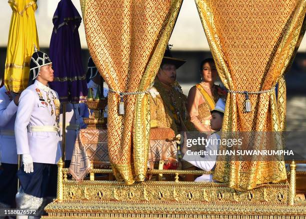 Thailand's King Maha Vajiralongkorn , his wife Queen Suthida and Prince Dipangkorn Rasmijoti sit at the Royal barge during the Royal Barge...