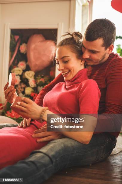 young woman opening her valentine's day gift - man giving flowers stock pictures, royalty-free photos & images