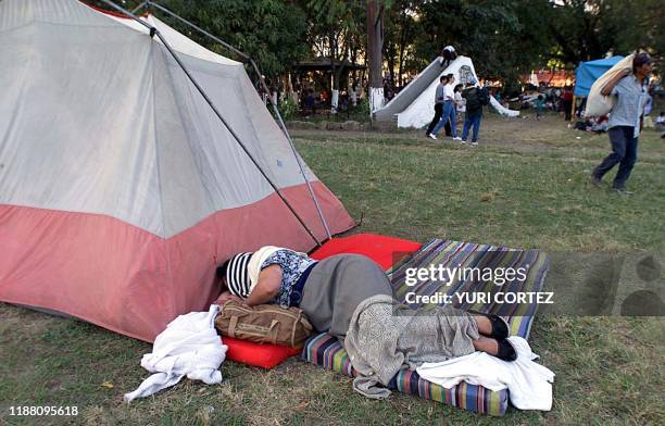 Woman sleeps 154 January 2001 next to a tent, a temporary house for homeless by the 13 January earthquake, in Santa Tecla, El Salvador. Una mujer...