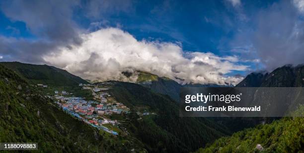 Panoramic aerial view over the town, Mt. Thamserku covered in monsoon clouds in the distance.
