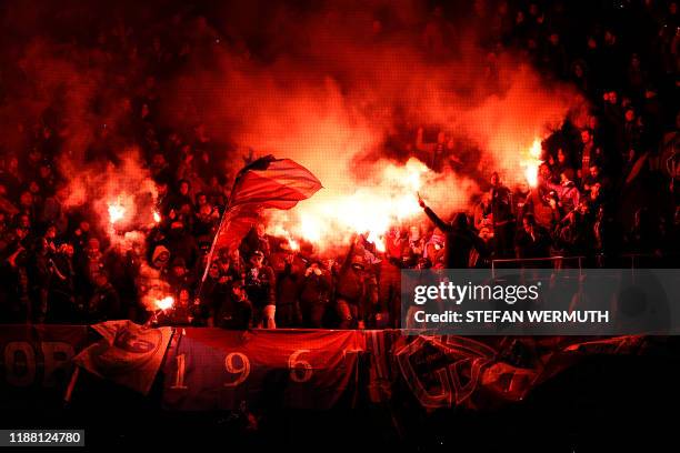 Trabzonspor's supporters hold red flares and flags during the UEFA Europa League Group D football match between FC Basel 1893 and Trabzonspor AS at...