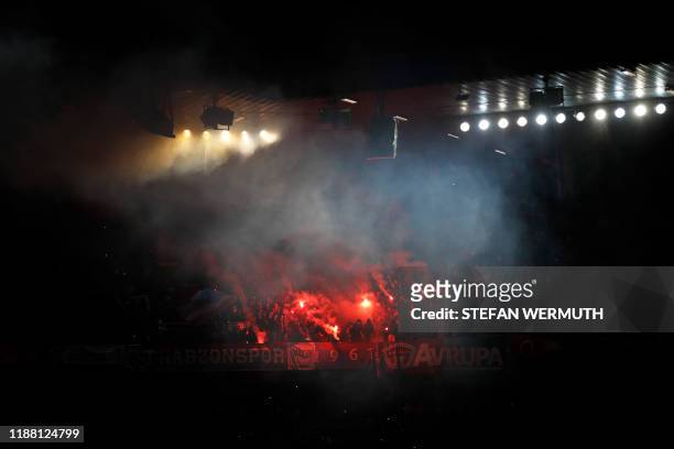 Trabzonspor's supporters hold red flares and flags during the UEFA Europa League Group D football match between FC Basel 1893 and Trabzonspor AS at...