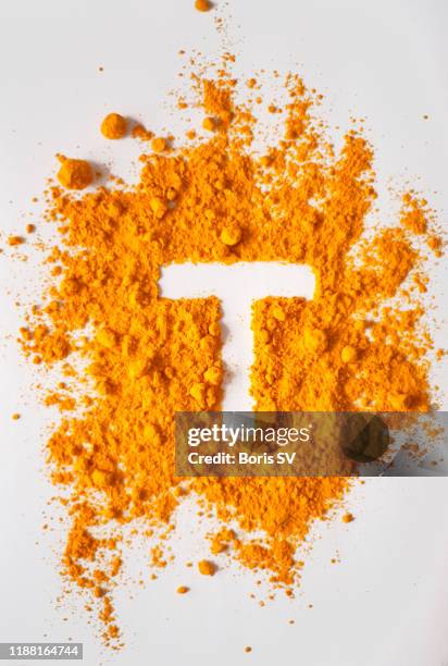 turmeric powerd forming letter t - at t stockfoto's en -beelden