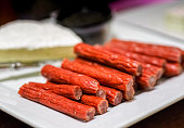 Preserved salami or meat sticks (red) in the foreground