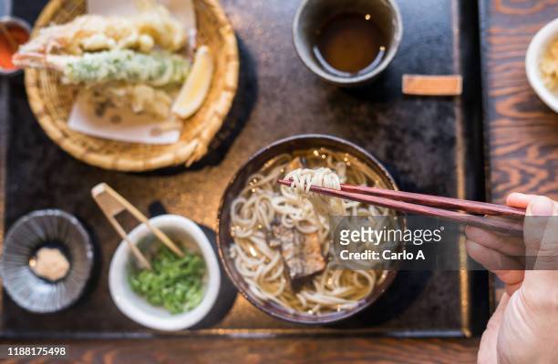 overhead first person  view of hands eating ramen soup - 天ぷら ストックフォトと画像