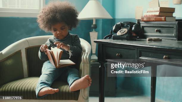 little girl reading a book story - small smart girl stock pictures, royalty-free photos & images