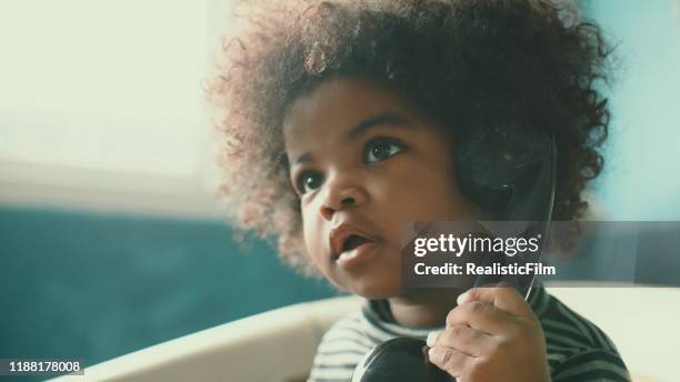 little girl talking on telephone at home - african american baby girls stock pictures, royalty-free photos & images