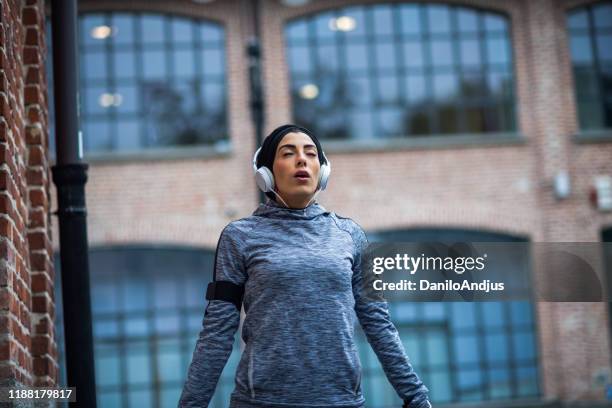 young athlete woman taking a break from her run - buff headwear stock pictures, royalty-free photos & images