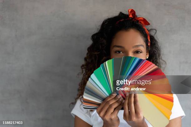 donna che dipinge la sua casa e tiene in mano una tavolozza di colori - colore descrittivo foto e immagini stock