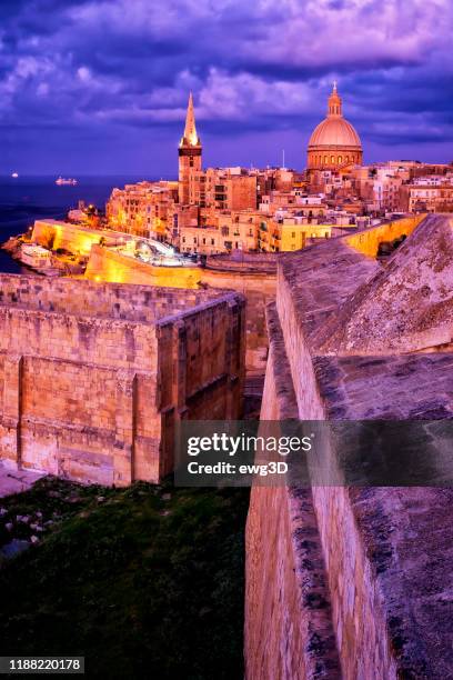 nachtzicht op de oude stad van valletta met de kathedraal van saint paul en de haven van marsamxett, malta - marsaxlokk stockfoto's en -beelden