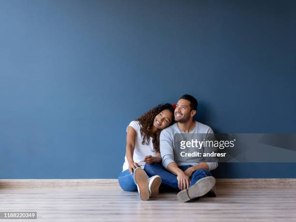 feliz pareja sonriendo en su nuevo hogar - contemplation couple fotografías e imágenes de stock