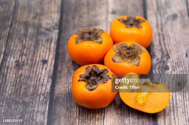 persimmon fruit on old wooden background, top view. - kaki stockfoto's en -beelden