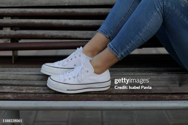 young woman with sneakers on bench - chaussures blanches photos et images de collection
