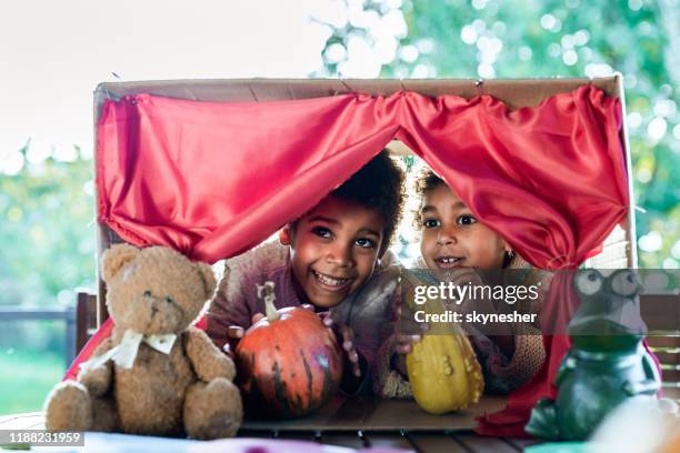 happy black kids having a puppet show on a terrace. - puppet show stage stock pictures, royalty-free photos & images