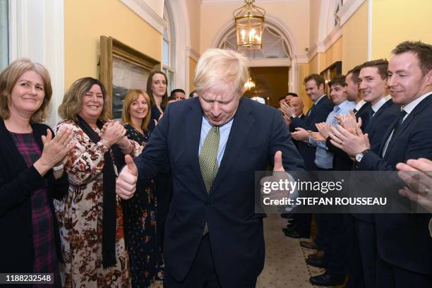 Britain's Prime Minister and Conservative Party leader Boris Johnson is greeted by staff as he arrives back at 10 Downing Street in central London on...