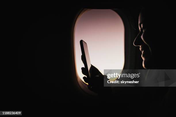 using cell phone in an airplane! - sunrise plane window stock pictures, royalty-free photos & images