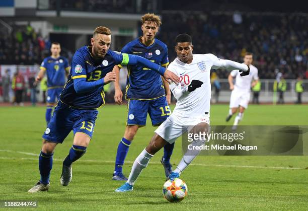 Marcus Rashford of England battles for possession with Mergim Vojvoda and Amir Rrahmani of Kosovo during the UEFA Euro 2020 Qualifier between Kosovo...