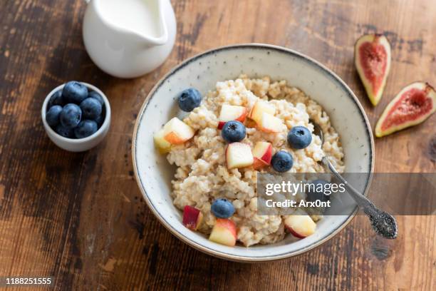 oatmeal porridge in a bowl with fruits and berries - oatmeal - fotografias e filmes do acervo