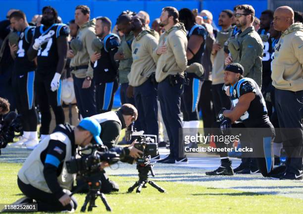 Eric Reid of the Carolina Panthers kneels on the sideline during the singing of the National Anthem before their game against the Atlanta Falcons at...