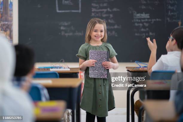 weinig kaukasische meisje presenteren aan haar klasse - kid presenting stockfoto's en -beelden