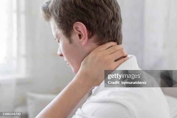 hombre con dolor de cuello - lesión de latigazo cervical fotografías e imágenes de stock