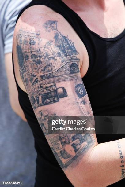 Fan shows off a tattoo featuring Ayrton Senna, Michael Schumacher and Lewis Hamilton of Great Britain and Mercedes GP during the F1 Grand Prix of...