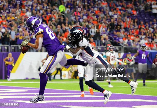 Irv Smith Jr. #84 of the Minnesota Vikings makes his first career NFL touchdown pass reception against Davontae Harris of the Denver Broncos in the...