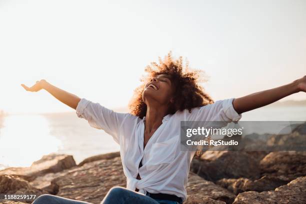 afro girl enjoying the sea idyll - liberation imagens e fotografias de stock