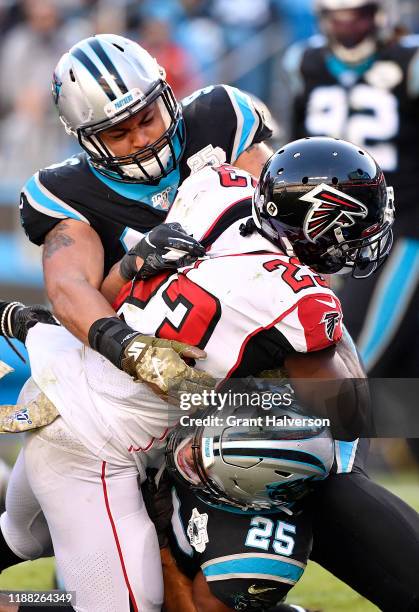 Wes Horton and Eric Reid of the Carolina Panthers tackle Brian Hill of the Atlanta Falcons during the third quarter of their game at Bank of America...