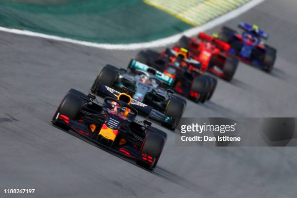 Max Verstappen of the Netherlands driving the Aston Martin Red Bull Racing RB15 leads Lewis Hamilton of Great Britain driving the Mercedes AMG...