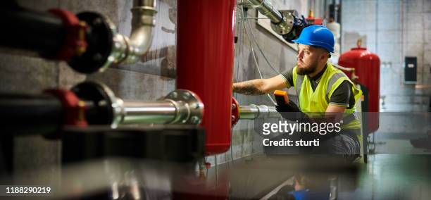 inspectie van verwarmings uitwisseling - plumber man stockfoto's en -beelden