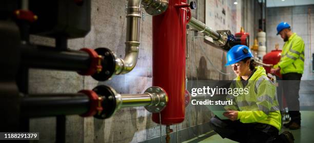 female engineer in turbine room - boiler engineer stock pictures, royalty-free photos & images