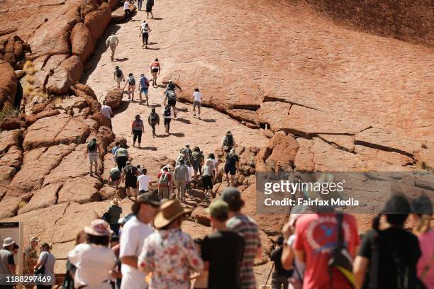 Tourists climb to the summit of Uluru in the Northern Territory on the last day the guided walking track is open, October 25, 2019. The Anganu,...