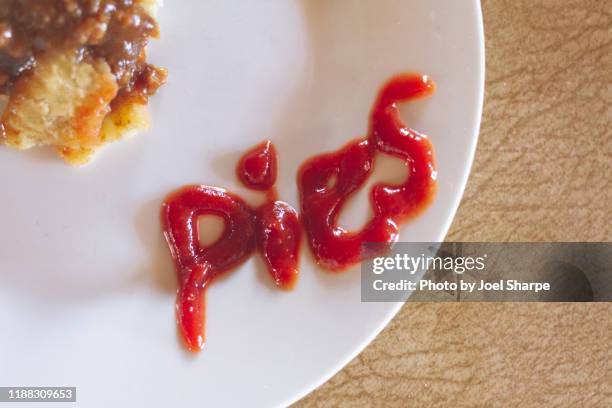 half eaten australian meat pie and sauce - meat pie stockfoto's en -beelden