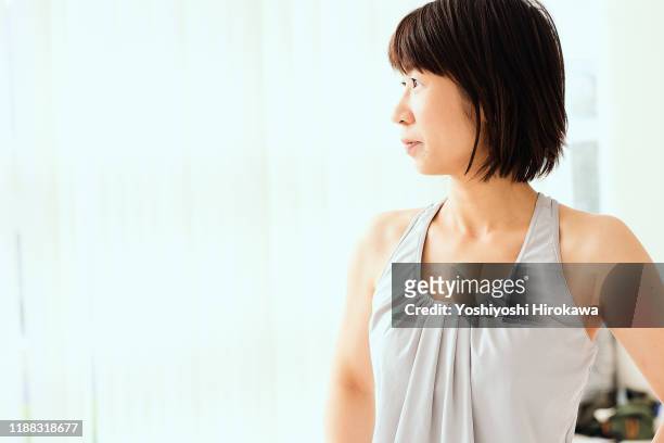portrait of mature japanese woman in fitness studio - business frau profil kurze haare stock-fotos und bilder